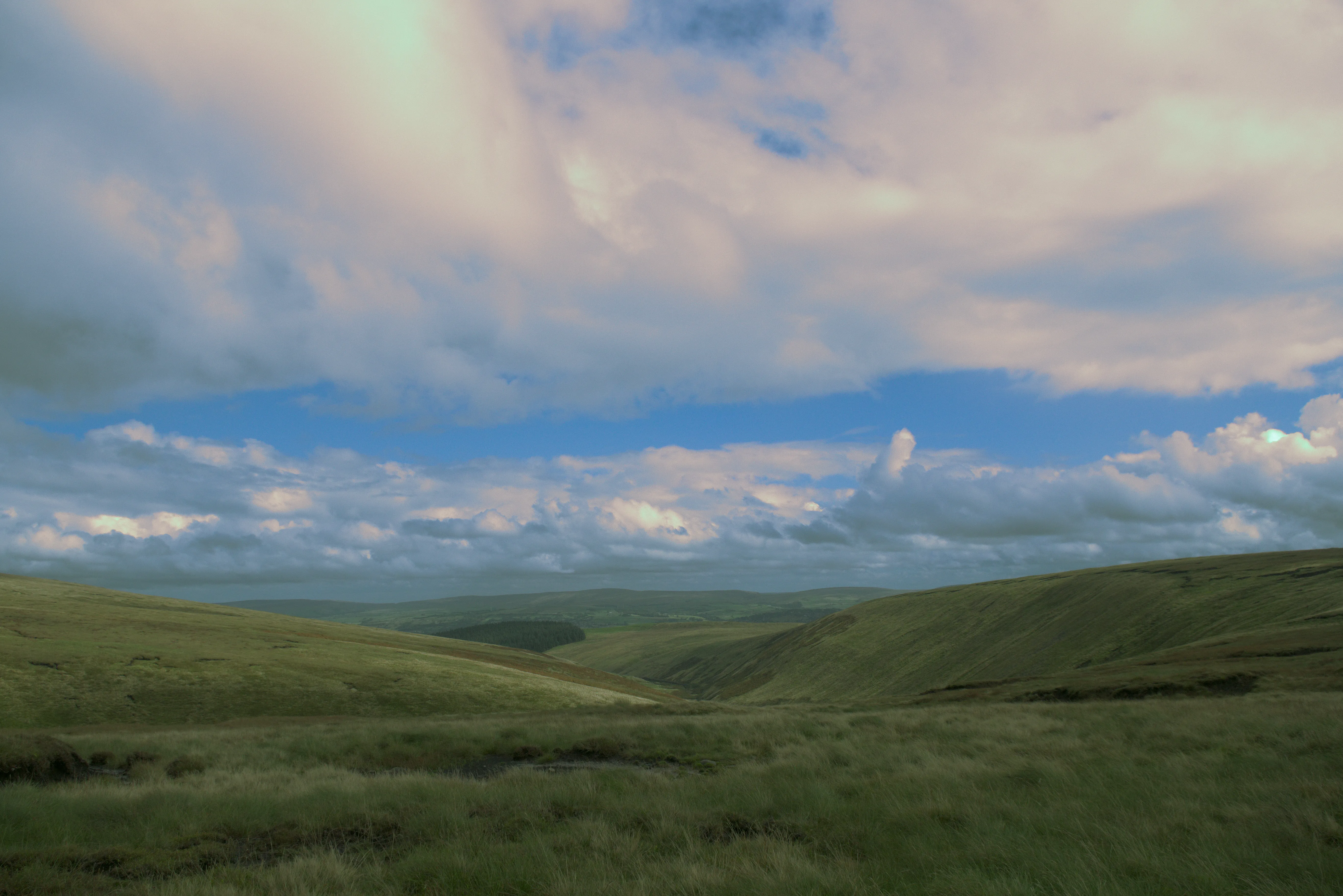 Rolling green hills under a cloudy sky